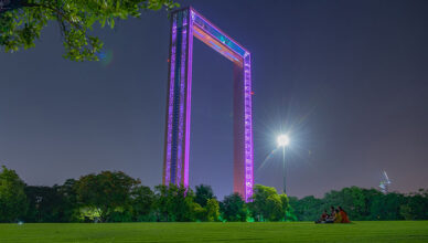 Dubai Frame illuminated at night, showcasing its towering golden structure against the dark sky