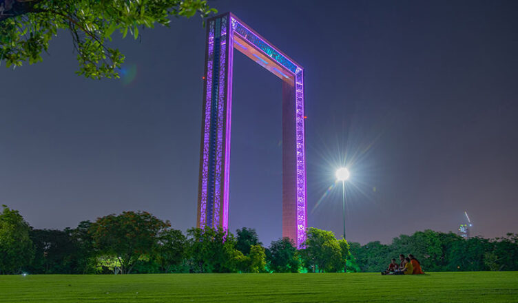 Dubai Frame illuminated at night, showcasing its towering golden structure against the dark sky